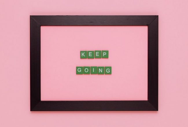 A framed motivational quote on a pink background for inspiration.
