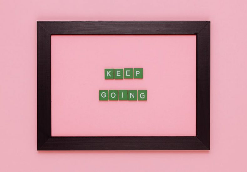 A framed motivational quote on a pink background for inspiration.